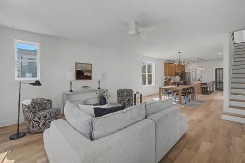 a living room with furniture a rug and a large window