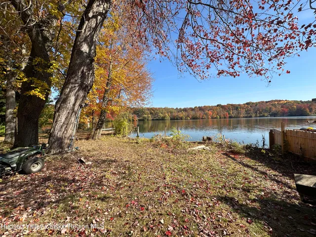 a backyard of a house with lots of green space and lake view