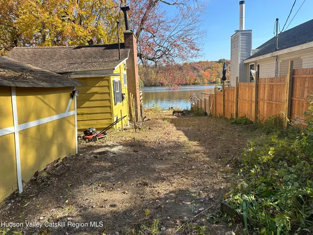 a view of backyard with potted plants and large tree