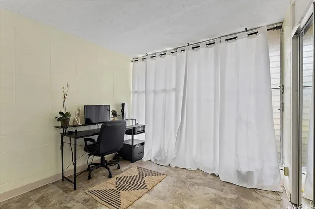 a view of a workspace with furniture and a window