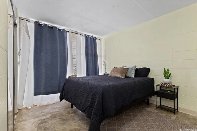 a bedroom with a bed table and a window
