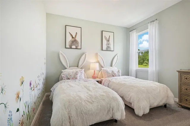 a bedroom with two beds and a painting on the wall