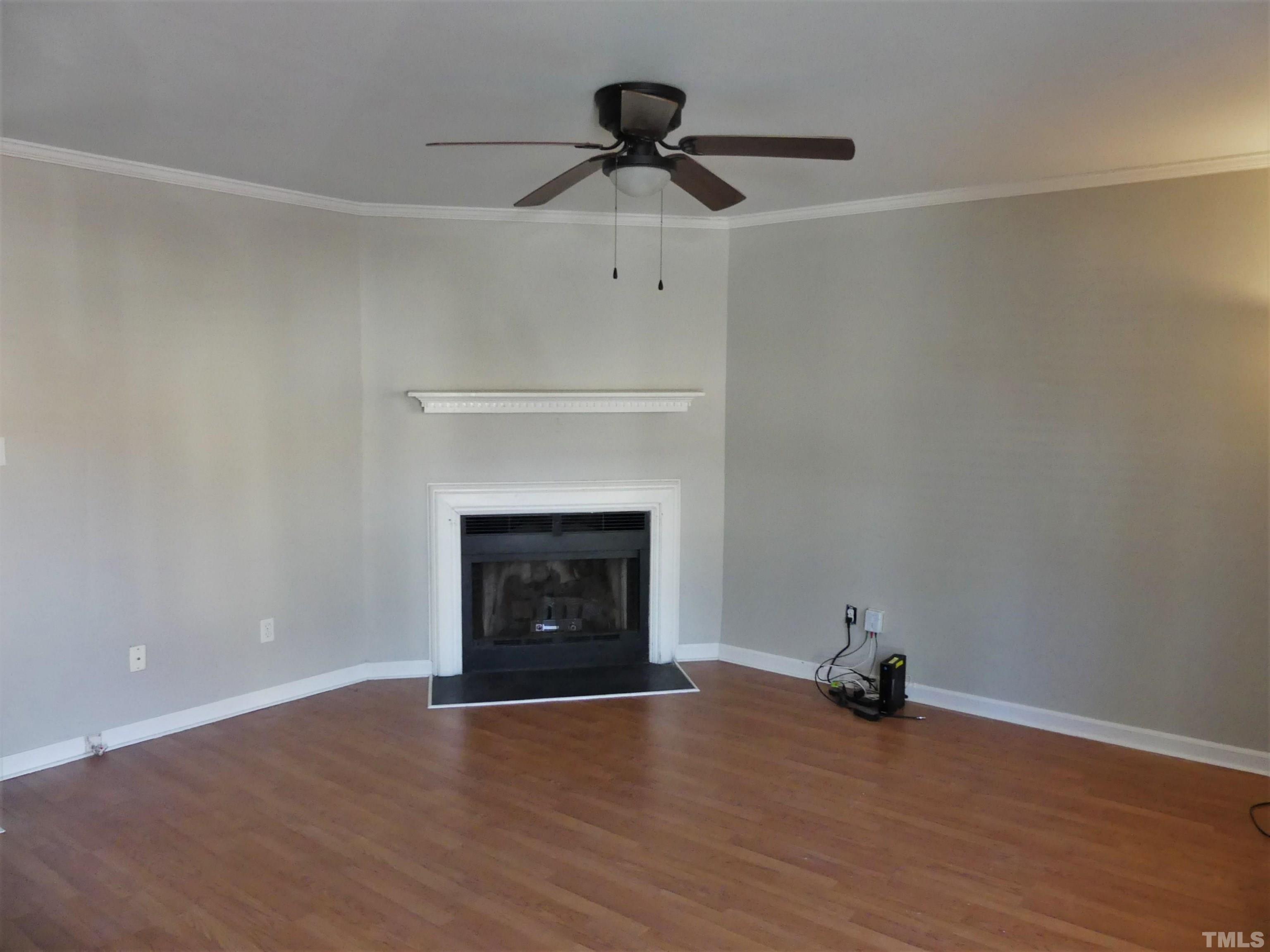 6520 English Oaks Drive Raleigh, NC 27615 - Photo 3 of 21 a view of an empty room with wooden floor and a fireplace