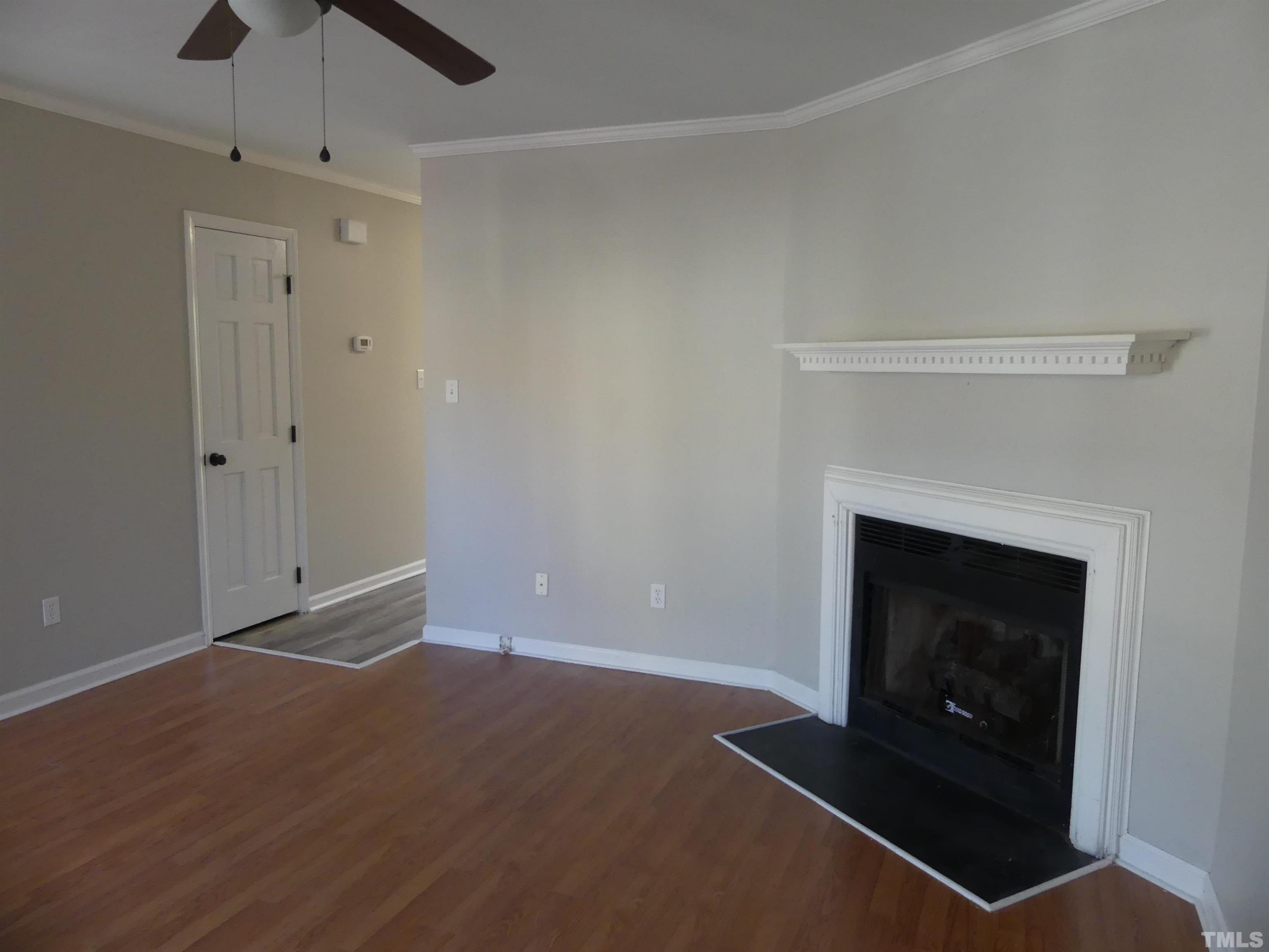 6520 English Oaks Drive Raleigh, NC 27615 - Photo 4 of 21 a living room with a fireplace and a ceiling fan