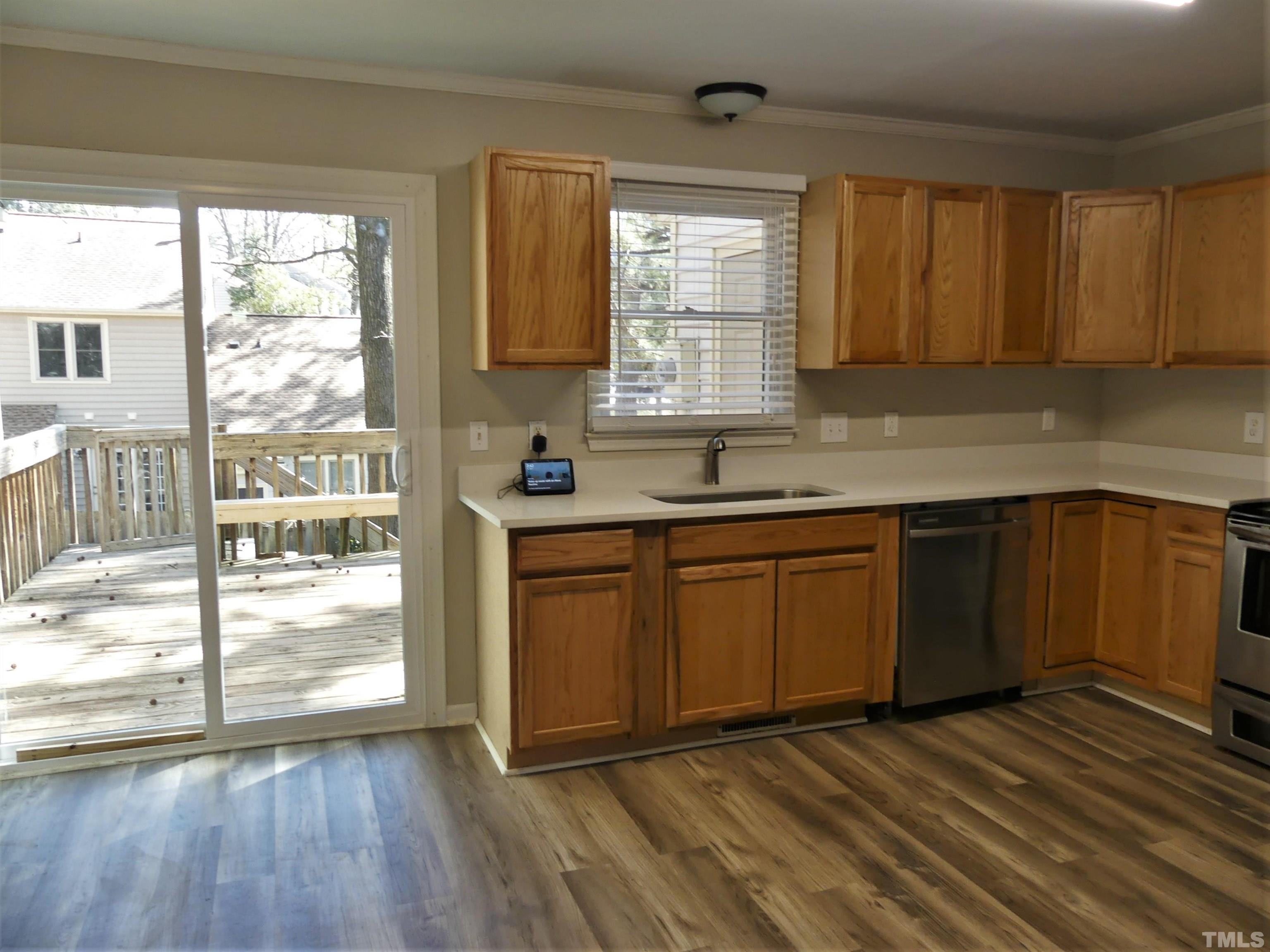 6520 English Oaks Drive Raleigh, NC 27615 - Photo 6 of 21 a kitchen with stainless steel appliances granite countertop wooden cabinets a sink and dishwasher with wooden floor