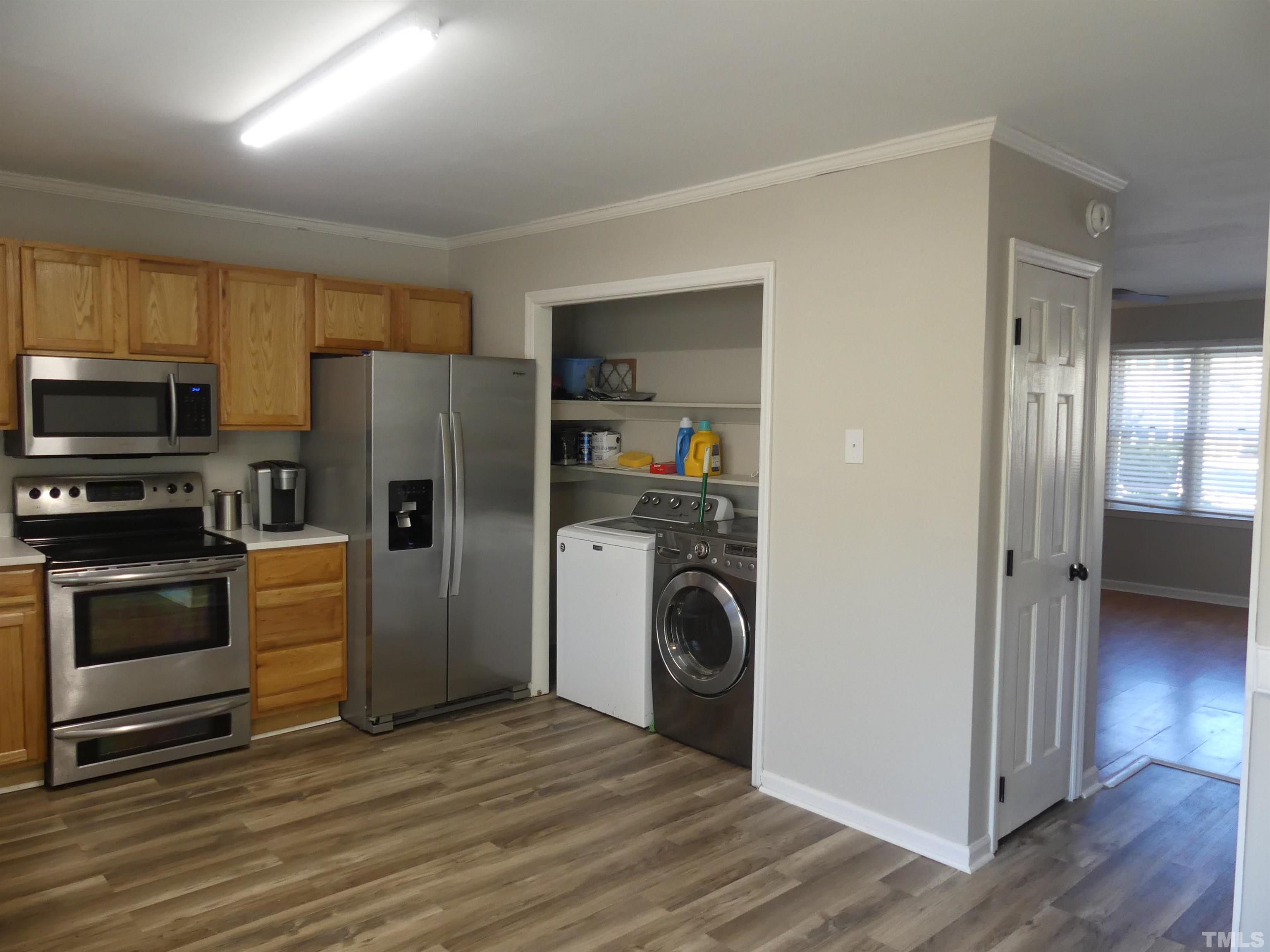 6520 English Oaks Drive Raleigh, NC 27615 - Photo 8 of 21 a kitchen with a refrigerator and a stove top oven