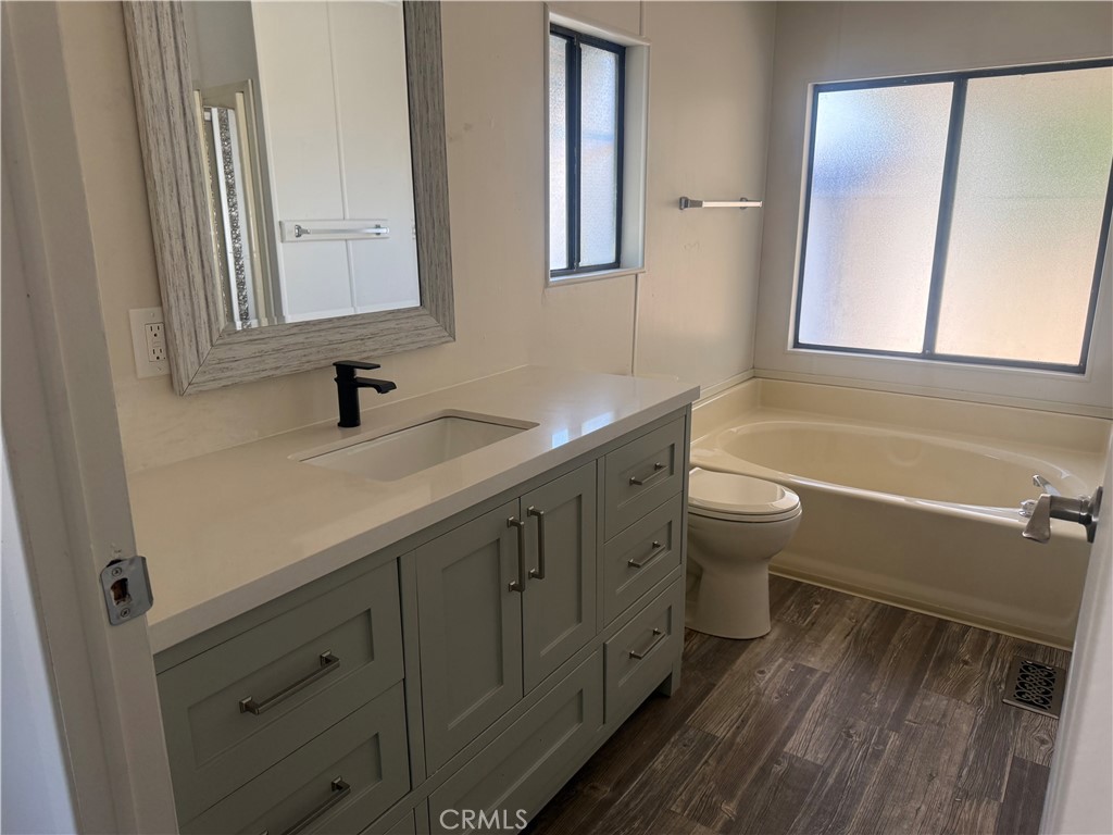 15181 Van Buren, Unit 256 Riverside, CA 92504 - Photo 17 of 34 a bathroom with a granite countertop sink mirror vanity bathtub and a toilet