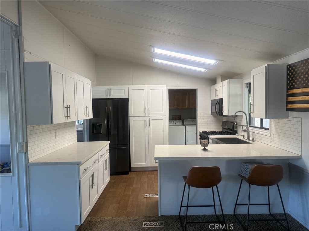 15181 Van Buren, Unit 256 Riverside, CA 92504 - Photo 9 of 34 a kitchen with stainless steel appliances kitchen island granite countertop a sink and cabinets