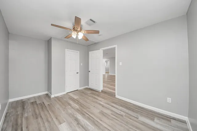 a view of empty room with wooden floor