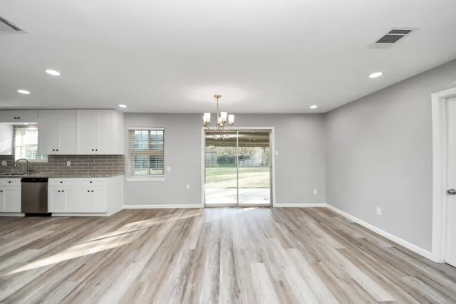 a open kitchen with granite countertop a large window and white appliances