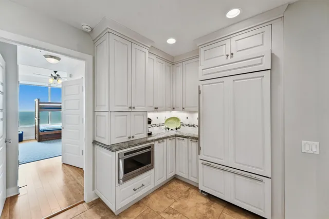 a kitchen with stainless steel appliances white cabinets and wooden floors