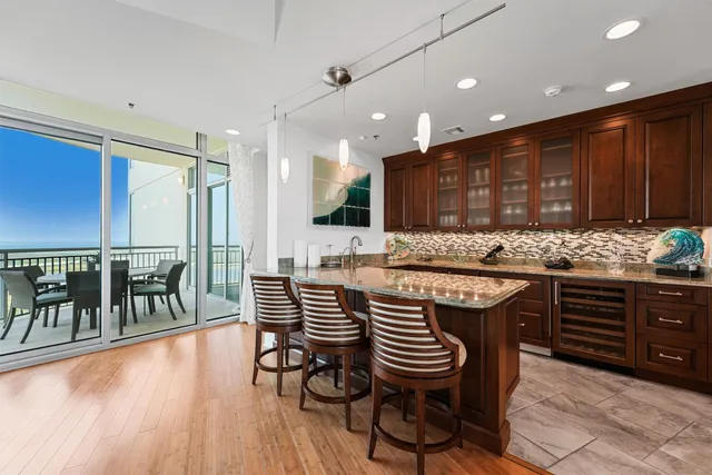 a kitchen with stainless steel appliances granite countertop a kitchen island wooden floors and wooden cabinets