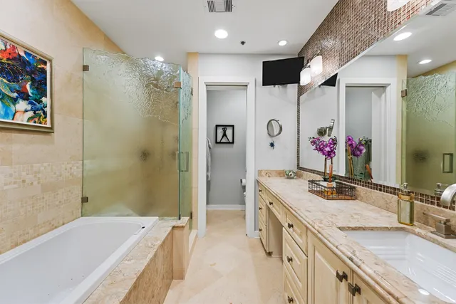 a bathroom with a granite countertop double vanity sink mirror and shower