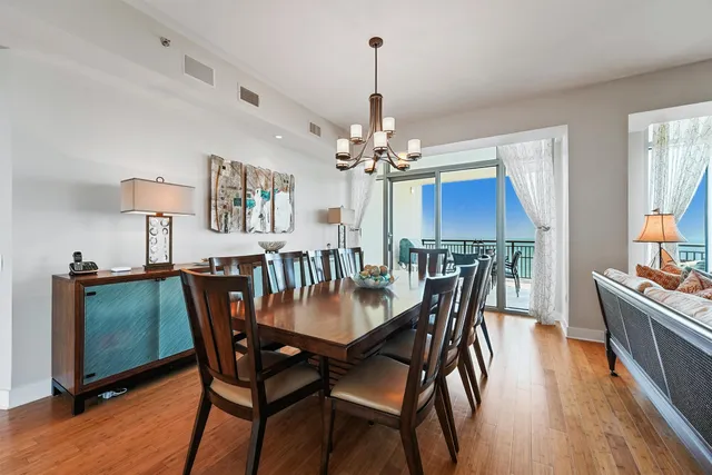 a dining room with furniture a chandelier and wooden floor