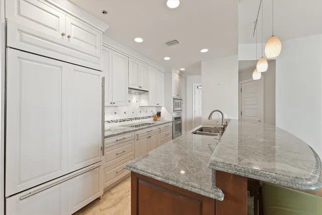 a kitchen with kitchen island a sink stainless steel appliances and cabinets