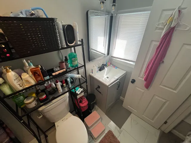 a bathroom with a toilet sink and mirror