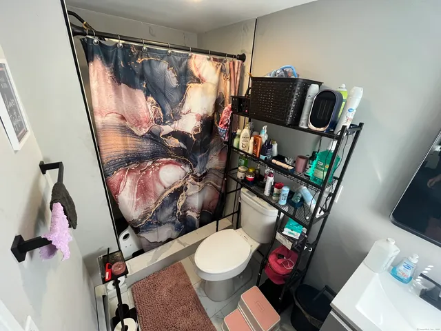 a bathroom with a toilet sink and mirror