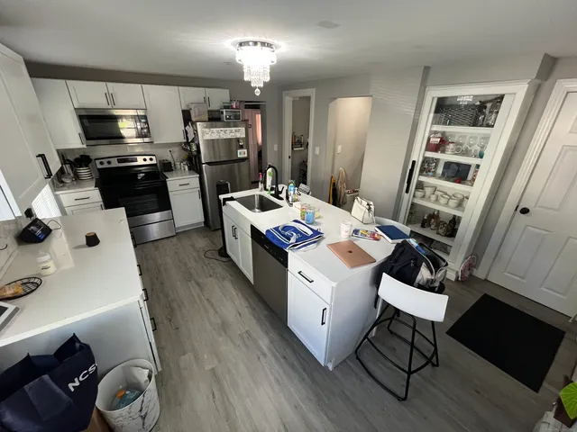 a kitchen that has a sink a microwave a stove and refrigerator