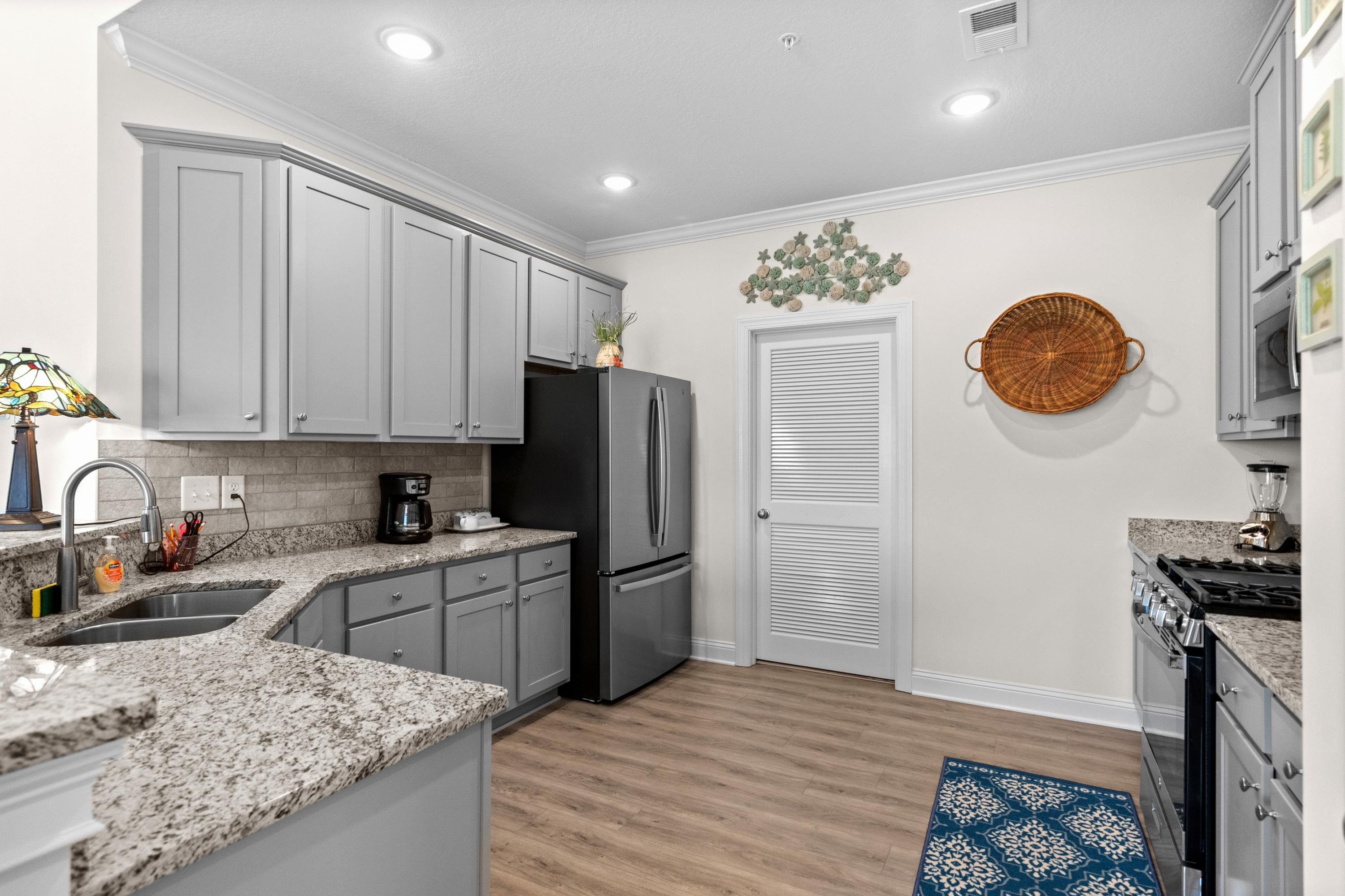 948 Jackline Place, Unit 201 Murrells Inlet, SC 29576 - Photo 15 of 37 Kitchen with gray cabinets, appliances with stainless steel finishes, light stone counters, light wood-style flooring, and ornamental molding