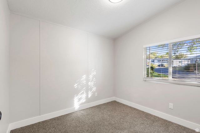 96 Barrington Way Layton, UT 84041 - Photo 9 of 28 Carpeted empty room featuring vaulted ceiling and baseboards
