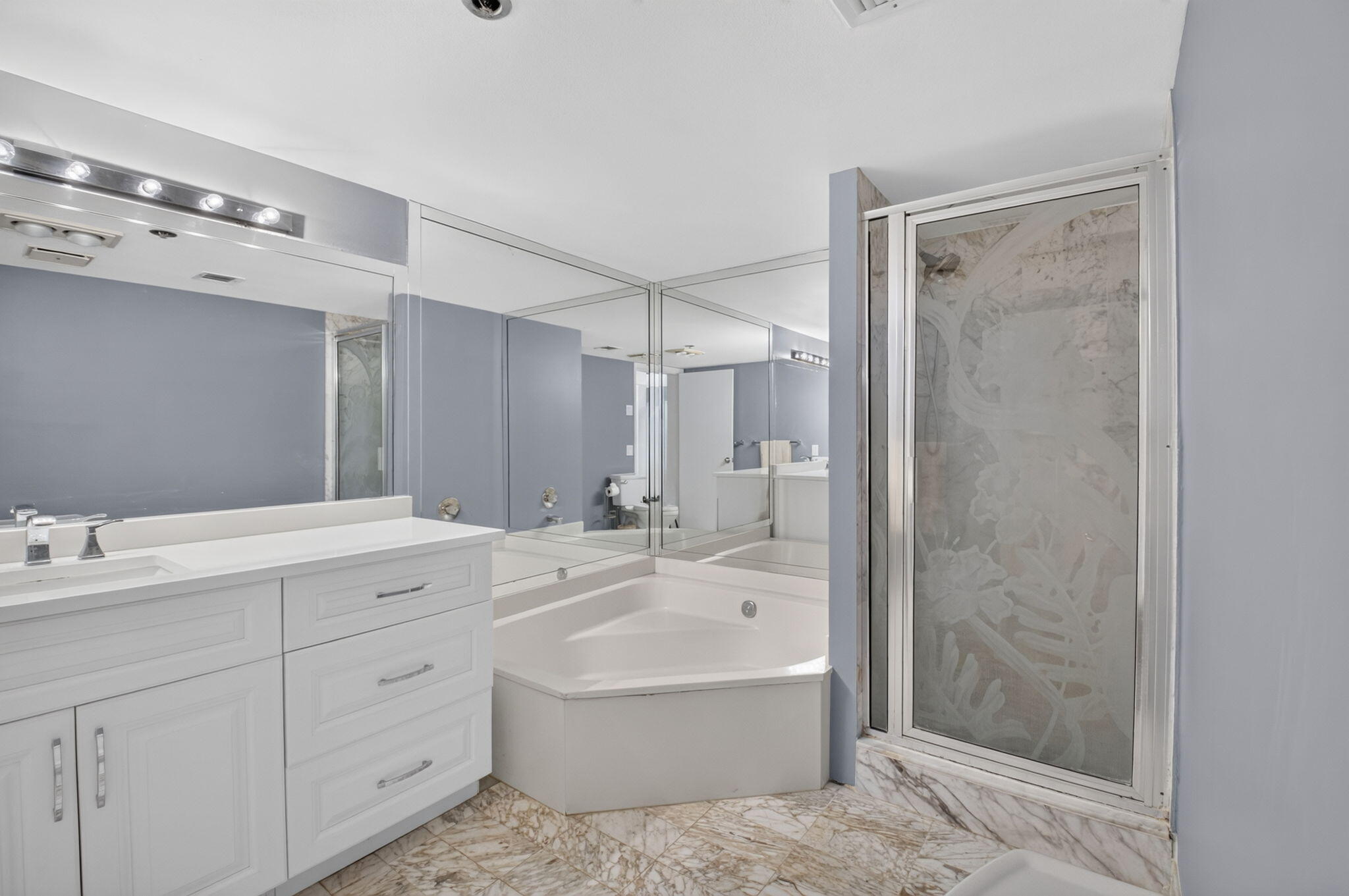 1401 South Ocean Boulevard, Unit 1060 Boca Raton, FL 33432 - Photo 21 of 46 a bathroom with a bathtub shower sink vanity and mirror