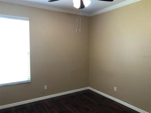 a view of a small space with wooden floor and a window