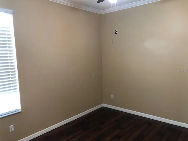 a view of a small space with wooden floor and a window
