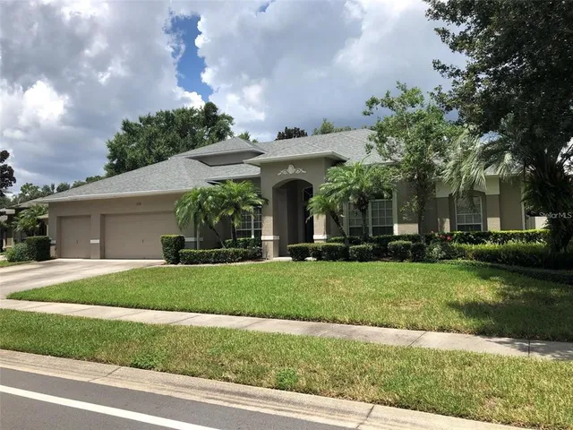 a view of a house with a yard and potted plants