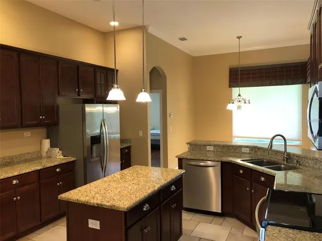a kitchen with a sink refrigerator and cabinets