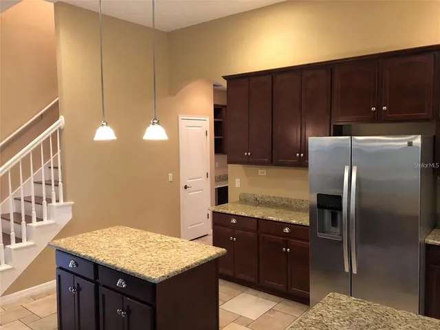a kitchen with stainless steel appliances kitchen island granite countertop wooden cabinets and granite counter tops