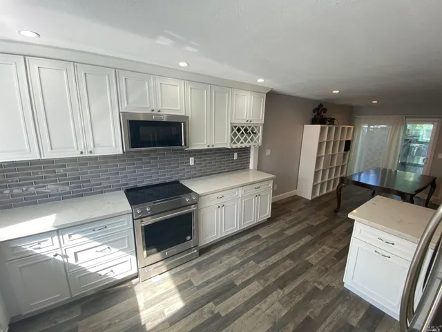 a kitchen with a refrigerator and a stove top oven