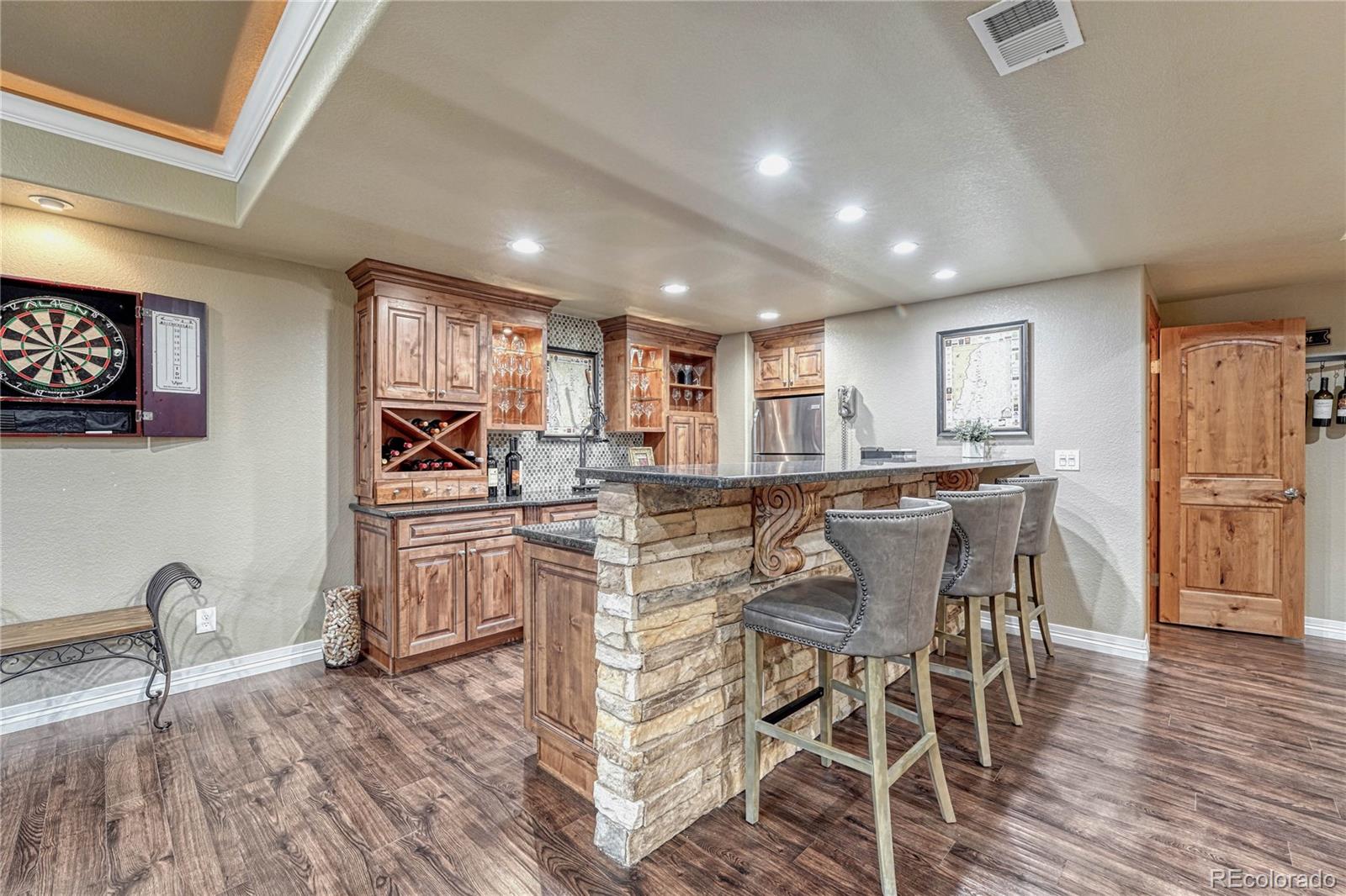 20125 East Shady Ridge Road Parker, CO 80134 - Photo 24 of 40 a kitchen with stainless steel appliances kitchen island granite countertop a dining table chairs and granite counter tops