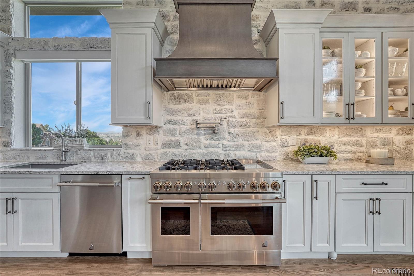 20125 East Shady Ridge Road Parker, CO 80134 - Photo 5 of 40 a kitchen with granite countertop a stove sink and cabinets