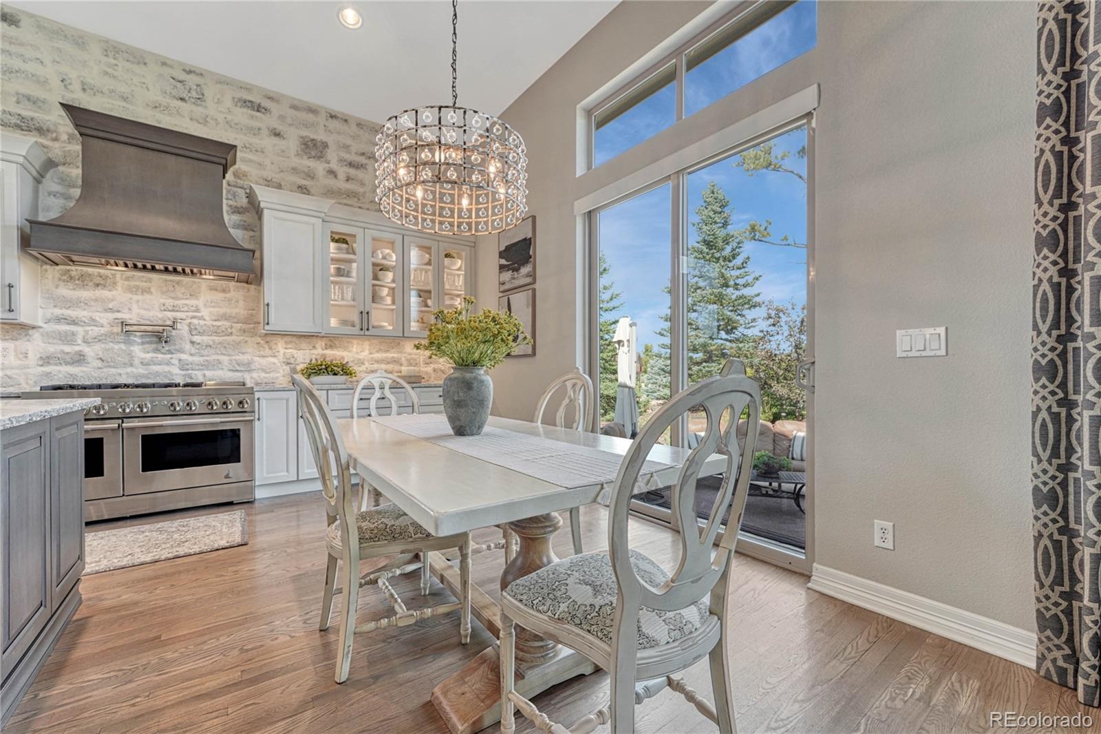 20125 East Shady Ridge Road Parker, CO 80134 - Photo 7 of 40 a dining room with furniture a chandelier and wooden floor