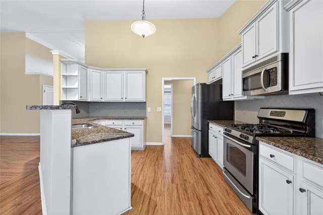 a kitchen with stainless steel appliances granite countertop a stove a sink and a refrigerator