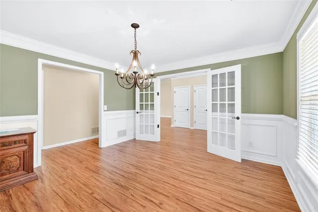 a view of a livingroom with wooden floor staircase and a kitchen