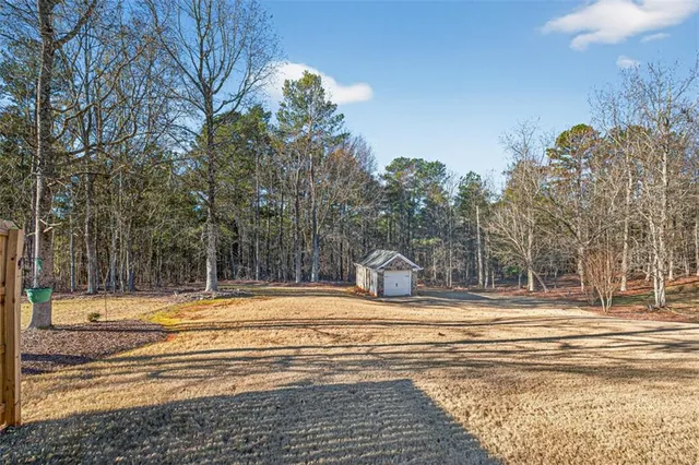 a view of a house with a yard and large tree