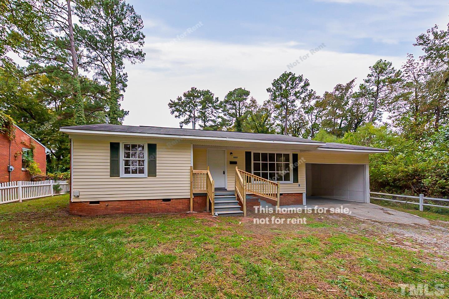 1217 Brighton Road Raleigh, NC 27610 - Photo 1 of 14 a backyard of a house with wooden deck table and chairs