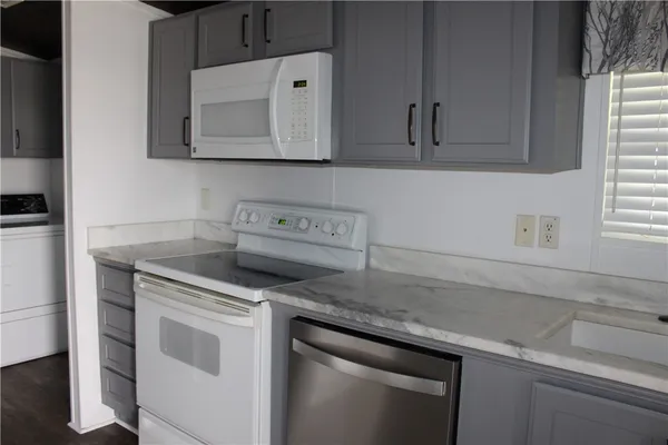 a kitchen with granite countertop cabinets stainless steel appliances and a sink