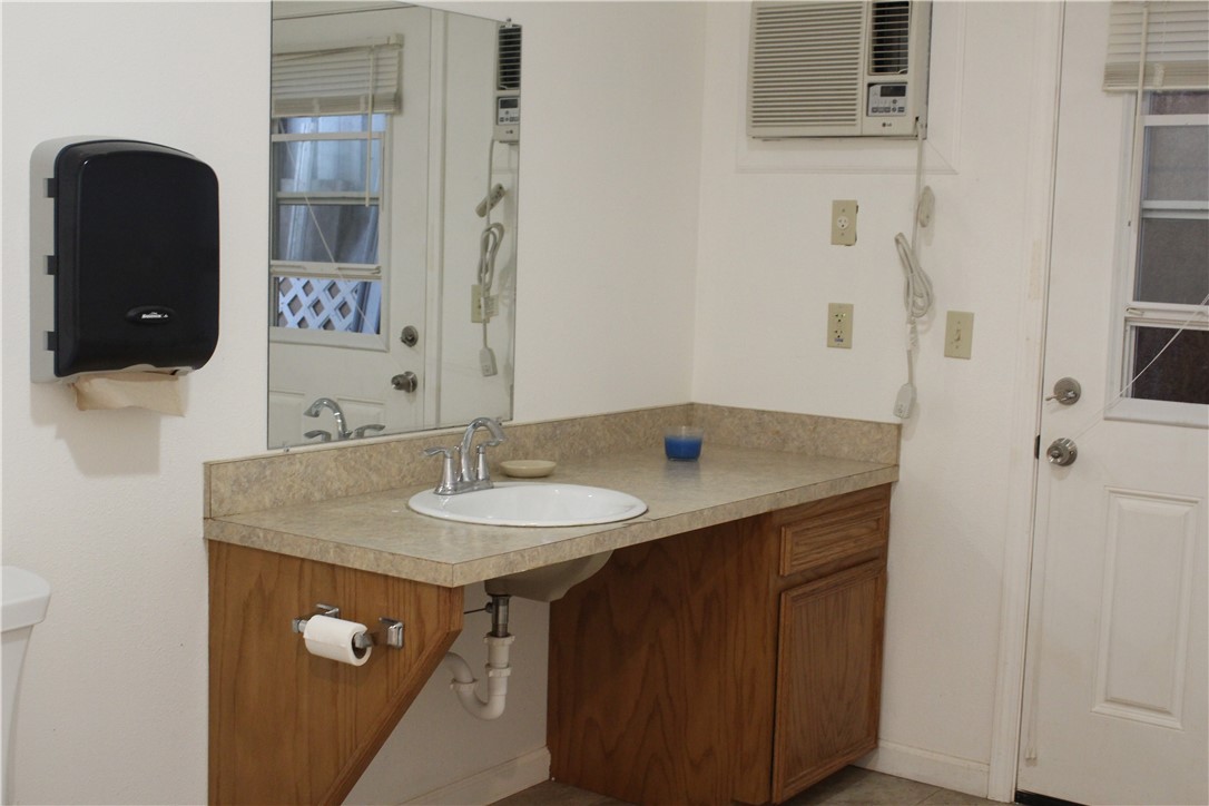 125 Lagarto Ferry Mathis, TX 78368 - Photo 13 of 38 a bathroom with a granite countertop sink a mirror and a shower
