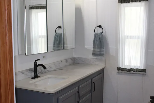 a bathroom with a sink and two mirror