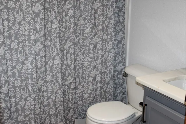 a white toilet sitting next to a shower curtain
