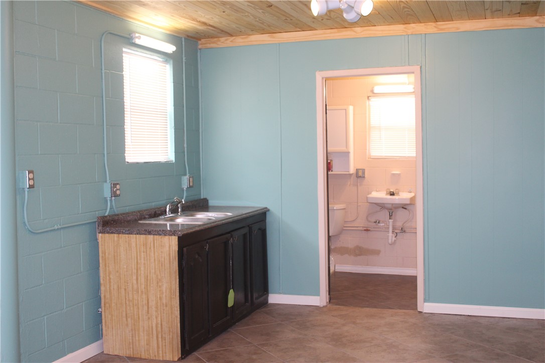 125 Lagarto Ferry Mathis, TX 78368 - Photo 29 of 38 a bathroom with a granite countertop sink and a mirror