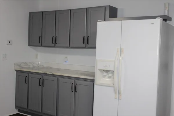 a kitchen with a white cabinets and a refrigerator