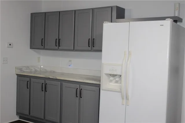 a kitchen with a white cabinets and a refrigerator