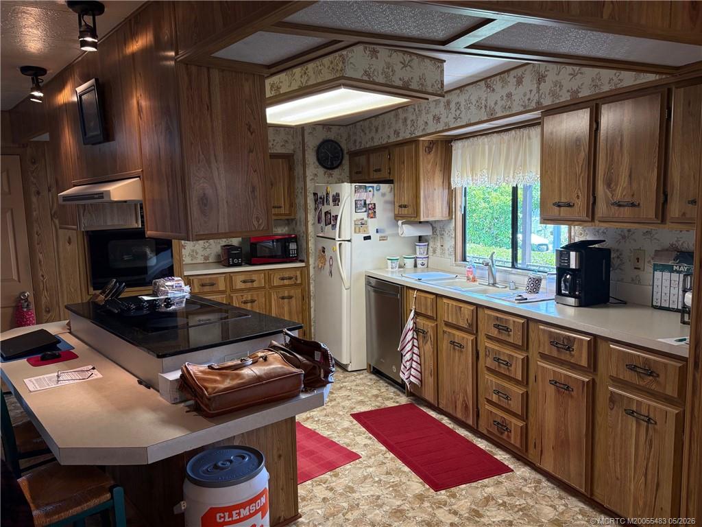 2856 Southwest Toronado Trail Stuart, FL 34997 - Photo 10 of 20 a kitchen with a stove a refrigerator and a sink