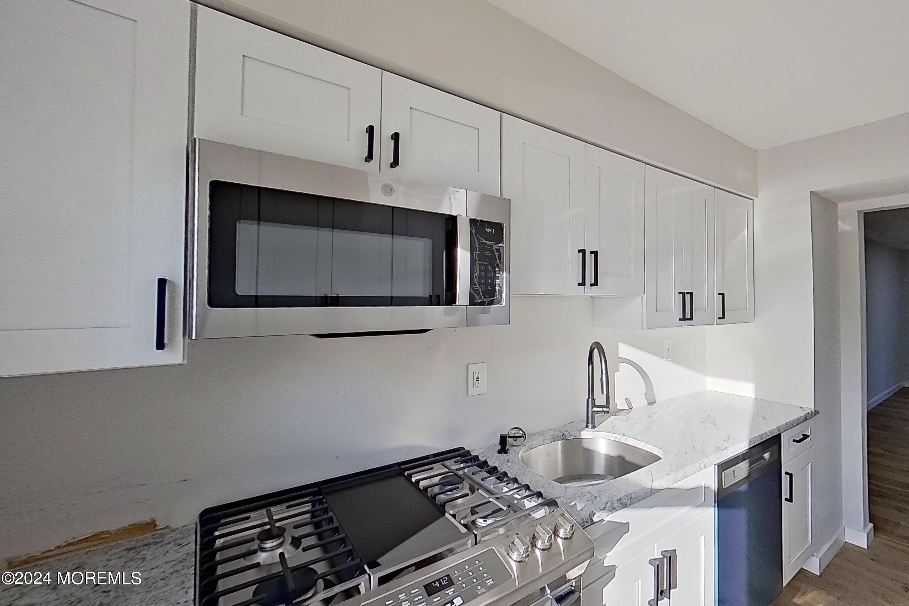 178 Sawmill Road, Unit 529 Brick, NJ 08724 - Photo 18 of 46 a kitchen with granite countertop a sink stove and microwave