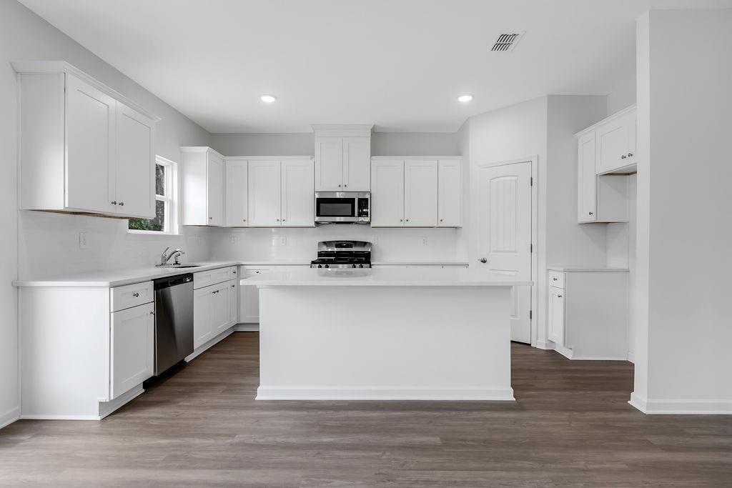 172 Sweet Water Lane Southeast Rome, GA 30161 - Photo 7 of 29 a kitchen with kitchen island wooden cabinets and stainless steel appliances