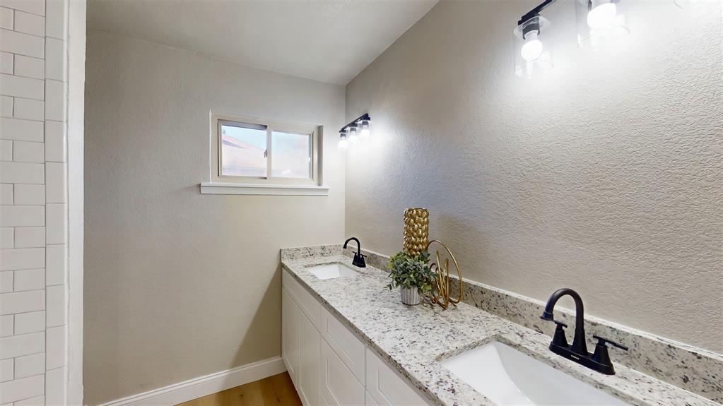 5009 Roxie Street Haltom City, TX 76117 - Photo 22 of 39 a bathroom with a granite countertop sink and a mirror