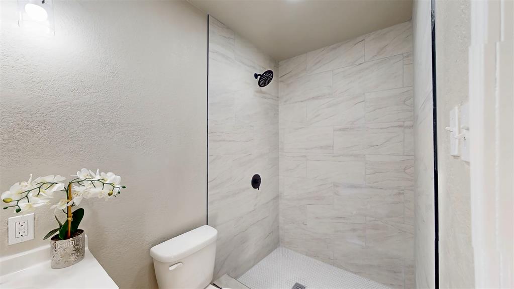 5009 Roxie Street Haltom City, TX 76117 - Photo 29 of 39 a bathroom with a toilet and shower